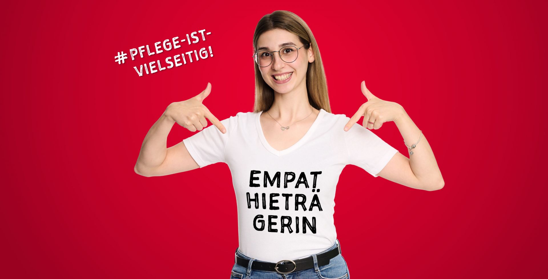 Eine junge Frau zeigt mit beiden Händen auf sich selbst. Auf ihrem T-Shirt steht "Empathieträgerin".