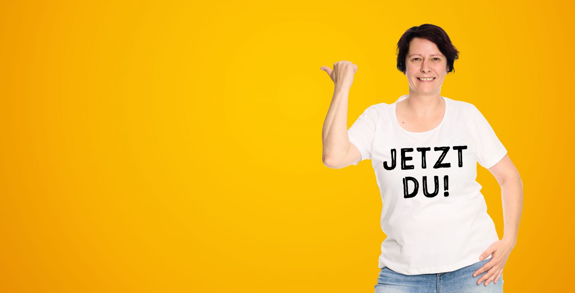 Eine Frau zeigt neben sich. Auf ihrem T-Shirt steht 